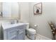 Small bathroom with gray vanity, white toilet, and a framed mirror at 8595 Old Daylily Ln, Las Vegas, NV 89113