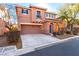 Two-story house with tan exterior, attached garage, and landscaping at 8809 Early Horizon Dr, Las Vegas, NV 89178