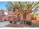 Two-story house with tan exterior, attached garage, and landscaping at 8809 Early Horizon Dr, Las Vegas, NV 89178