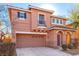 Two-story house with tan exterior, attached garage, and landscaping at 8809 Early Horizon Dr, Las Vegas, NV 89178