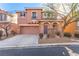 Two-story house with tan exterior, attached garage, and landscaping at 8809 Early Horizon Dr, Las Vegas, NV 89178