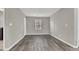 Neutral bedroom with wood-look floors, bright window, and a door at 9202 Valley Betica Ave, Las Vegas, NV 89148