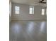Bright and airy living room featuring modern ceiling fan and three large windows at 10046 Dancing Lasso Ct, Las Vegas, NV 89178