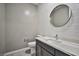 Modern bathroom with subway tile, dark vanity, and a round mirror at 10226 Jade Gardens Dr, Las Vegas, NV 89135