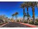 Community entrance with palm trees and paved road at 10229 Birch Bluff Ln, Las Vegas, NV 89145