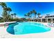 Community swimming pool with lounge chairs and palm trees at 10229 Birch Bluff Ln, Las Vegas, NV 89145