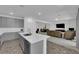 Open concept kitchen with gray cabinets and an island overlooking the living room at 1606 Dire Wolf Ave, North Las Vegas, NV 89084