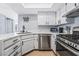 Modern kitchen with white cabinets, stainless steel appliances, and quartz countertops at 2039 Waverly Cir, Henderson, NV 89014