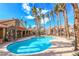 Inviting community pool with surrounding lounge chairs and palm trees at 2300 Silverado Ranch Blvd # 1070, Las Vegas, NV 89183