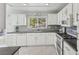 Modern kitchen with white cabinets, gray countertops, and tile backsplash at 2413 Hidden Glen Ct, Las Vegas, NV 89134