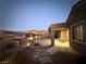 Landscaped backyard with patio and lighting at dusk at 2568 Dirleton Pl, Henderson, NV 89044