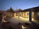 Evening view of backyard patio, covered seating area, and landscaped desert plants at 2568 Dirleton Pl, Henderson, NV 89044