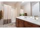 Bathroom with tub and shower, dark wood vanity, and neutral-toned tile flooring at 2568 Dirleton Pl, Henderson, NV 89044