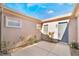 Private courtyard entry with a gray door and rose bushes at 2568 Dirleton Pl, Henderson, NV 89044