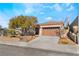 Single-story house with a brown garage door and landscaped front yard at 2568 Dirleton Pl, Henderson, NV 89044