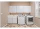 Bright laundry room, washer, dryer, cabinets, and sink at 2568 Dirleton Pl, Henderson, NV 89044