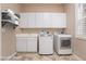 Well-equipped laundry room with modern washer, dryer and ample cabinet storage at 2568 Dirleton Pl, Henderson, NV 89044