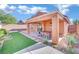 Spacious backyard with covered patio, artificial turf, and desert landscaping at 2736 Mintlaw Ave, Henderson, NV 89044