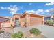 Single-story house with tan exterior, two-car garage, and landscaped yard at 2736 Mintlaw Ave, Henderson, NV 89044