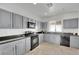 Modern kitchen with gray cabinets, granite countertops, and stainless steel appliances at 2736 Mintlaw Ave, Henderson, NV 89044