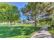 Scenic community park with lush grass, mature trees, and a walking path at 3128 Pelican Beach Dr, Las Vegas, NV 89117