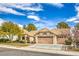 Tan house with tile roof, two car garage, and mature landscaping at 3128 Pelican Beach Dr, Las Vegas, NV 89117