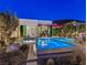 An inviting backyard features a modern pool with a spa and an outdoor dining area in a contemporary setting at 371 Tranquil Peak Ct, Henderson, NV 89012