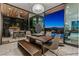 Indoor/outdoor dining area with modern table, bench seating, and views of the pool and outdoor kitchen at 371 Tranquil Peak Ct, Henderson, NV 89012