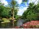 A picturesque entrance features lush greenery, including flowers and palm trees, leading to a gated community entrance at 371 Tranquil Peak Ct, Henderson, NV 89012