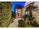 Modern home entrance featuring a vibrant red door, palm trees and verdant hedges for added privacy at 371 Tranquil Peak Ct, Henderson, NV 89012