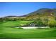 Aerial view of green golf course with water features and mountain backdrop at 371 Tranquil Peak Ct, Henderson, NV 89012