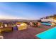 Outdoor patio with a fire pit, dining table, spa and seating that overlooks the cityscape at 371 Tranquil Peak Ct, Henderson, NV 89012