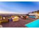 Outdoor patio with a fire pit, dining table, spa and seating that overlooks the cityscape at 371 Tranquil Peak Ct, Henderson, NV 89012