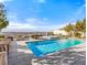 Backyard features a pool, spa, outdoor seating with a fire pit, dining table and great city views at 371 Tranquil Peak Ct, Henderson, NV 89012