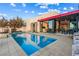 A modern outdoor pool with an attached spa and a dining table for entertaining guests at 371 Tranquil Peak Ct, Henderson, NV 89012