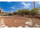 Large backyard with gravel, stone walkway, and mature shrubs at 392 Dooley Dr, Henderson, NV 89015