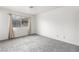 Spacious bedroom featuring gray carpet, window with beige curtains, and neutral walls at 392 Dooley Dr, Henderson, NV 89015