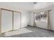 Bright bedroom with gray carpet, window with curtains, and mirrored closet doors at 392 Dooley Dr, Henderson, NV 89015