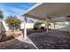 Landscaped backyard with covered patio and ceiling fan at 3920 Red Trumpet Ct, North Las Vegas, NV 89081