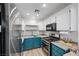 Modern kitchen with teal cabinets and concrete countertops at 4039 Halfmoon Bay Dr, Las Vegas, NV 89115