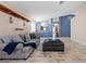 Living room with tiled floors, gray sofa, and a view into the kitchen at 6501 Grand Oaks Dr, Las Vegas, NV 89156