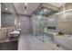 Spa-like bathroom with dual vanities, glass-enclosed shower, and soaking tub at 665 Overlook Rim Dr, Henderson, NV 89012