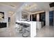 Modern kitchen with a large, illuminated island featuring seating and sleek, white cabinetry at 665 Overlook Rim Dr, Henderson, NV 89012