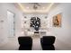 Modern office space featuring sleek white desk, statement art, and stylish decor for a sophisticated workspace at 665 Overlook Rim Dr, Henderson, NV 89012