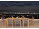 Outdoor patio with a large dining table and chairs overlooking the city lights at 665 Overlook Rim Dr, Henderson, NV 89012