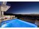 Infinity pool with city views at night, surrounded by lounge area at 665 Overlook Rim Dr, Henderson, NV 89012