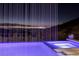 Relaxing pool and spa with a cascading waterfall and city lights at 665 Overlook Rim Dr, Henderson, NV 89012