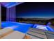 Stunning pool with illuminated waterfall feature and spa, offering panoramic city views at night at 665 Overlook Rim Dr, Henderson, NV 89012