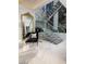 Elegant staircase with glass railings, complemented by a stylish chaise lounge and ornate mirror at 665 Overlook Rim Dr, Henderson, NV 89012