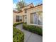 Front entry with walkway, shrubs, and light beige exterior at 6908 Emerald Springs Ln, Las Vegas, NV 89113